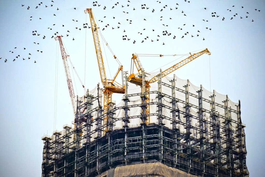 Tower cranes above a multi-storey building under construction