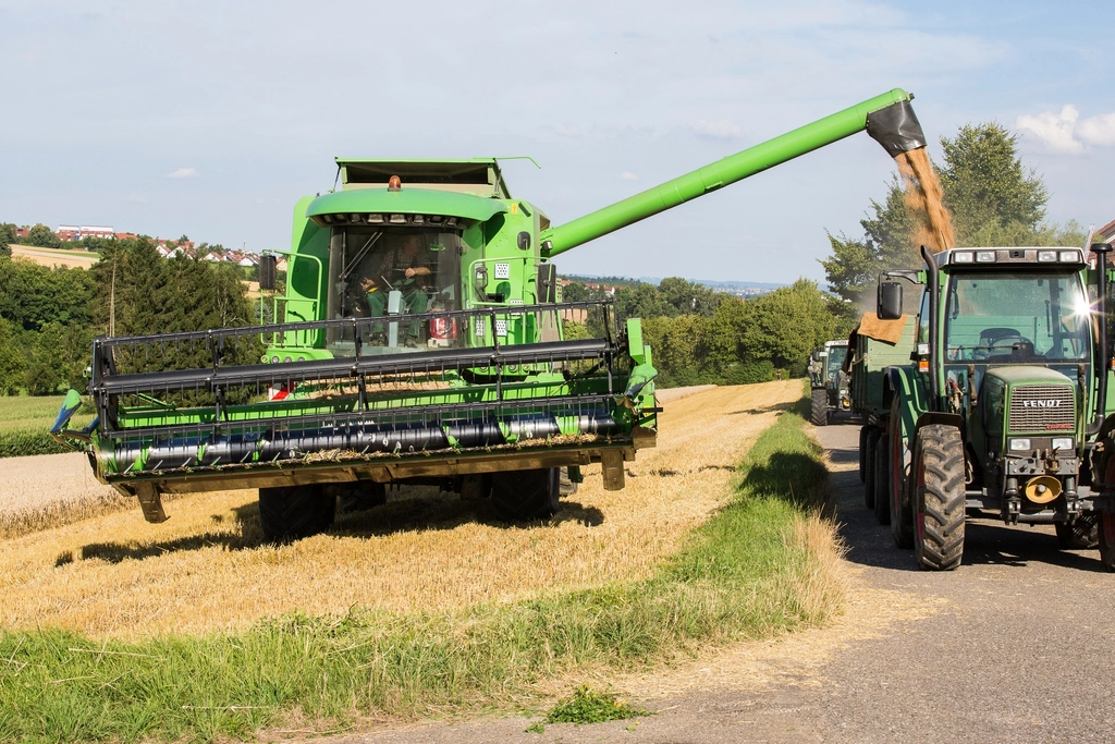 Combine harvester and tractor working a field at harvest