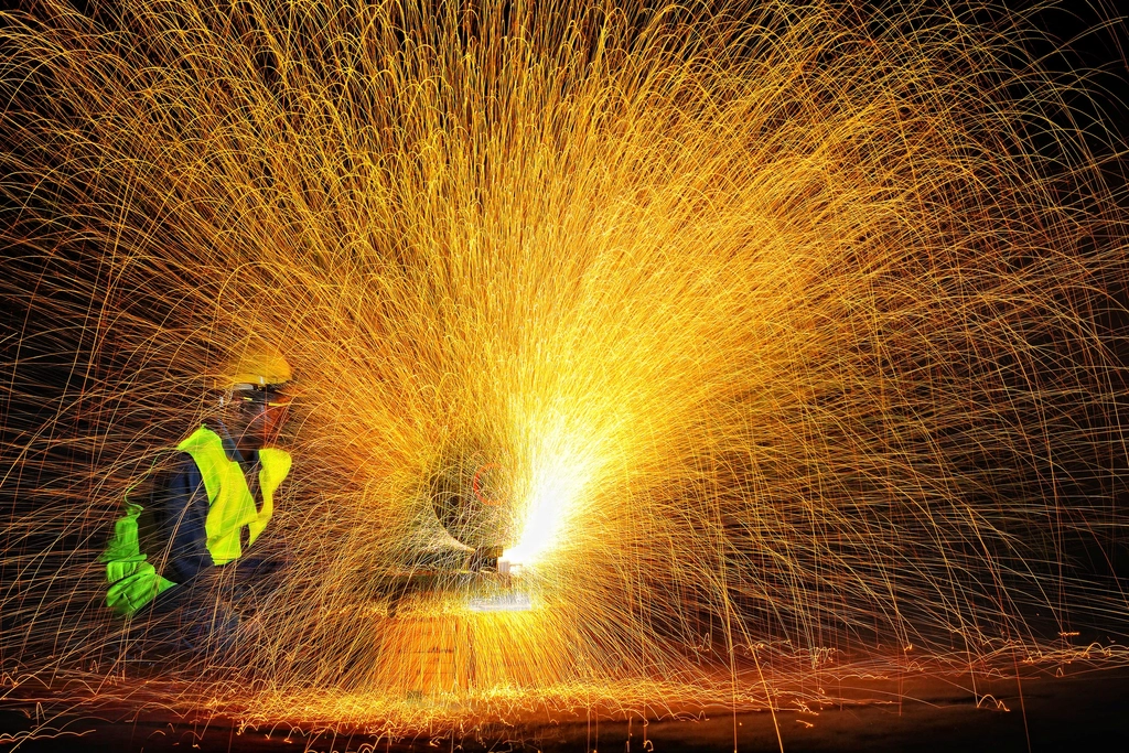 Sparks flying from welding work in a manufacturing workshop