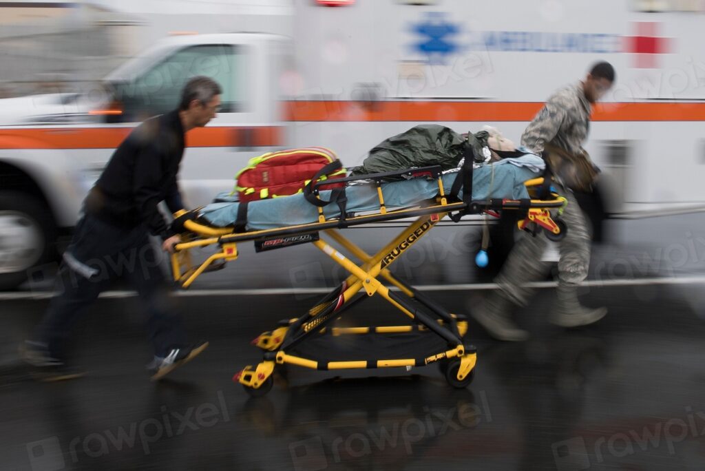 Emergency medical responders moving a patient on a stretcher